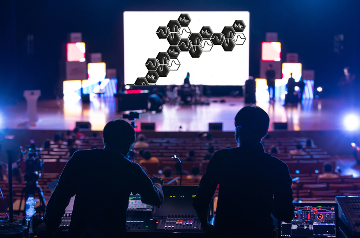 Nahaufnahme Veranstaltungstechniker am Technikpult vor Bühne mit Blick auf Leinwand mit Signets von Marcousi Events